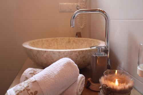 a bathroom with a large stone tub with a candle at Untertalhof in Castelrotto