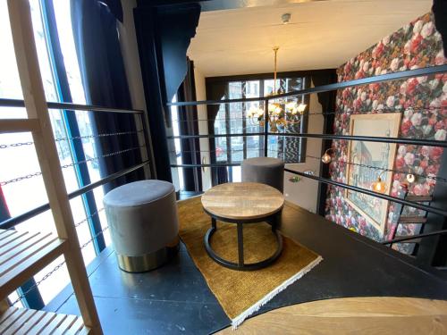 - une petite table et un tabouret dans une chambre avec fenêtres dans l'établissement Luxury Suites, à Anvers