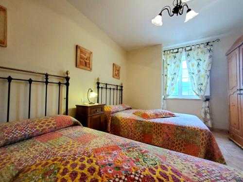 1 dormitorio con 2 camas y ventana en Viviendas Turísticas Rosa, en Ribadeo