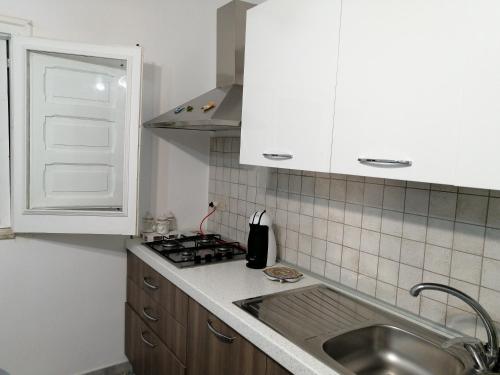 a small kitchen with a sink and a stove at Casa Maris in Santo Stefano di Camastra