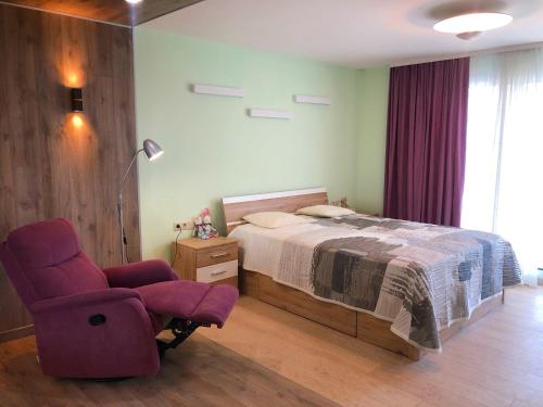 a bedroom with a bed and a chair at Comfy Retreat on Kotsubinsky street in Vinnytsya