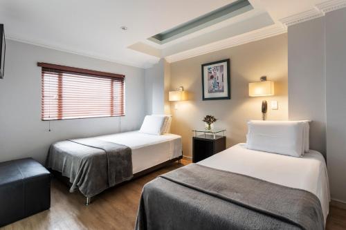 um quarto de hotel com duas camas e uma janela em Hotel Picasso Inn em Bogotá