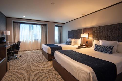 een hotelkamer met 2 bedden en een bureau bij Grand Hotel Tijuana in Tijuana