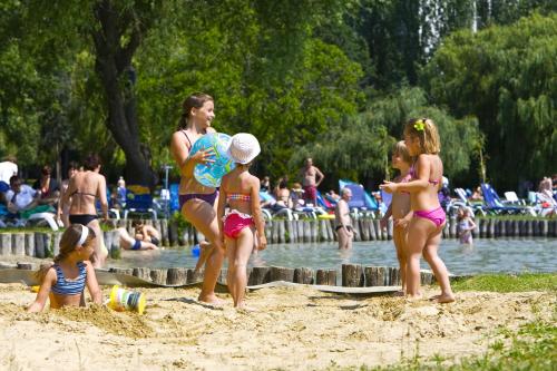 a group of children playing in the sand on the beach at Danubius Hotel Marina in Balatonfüred