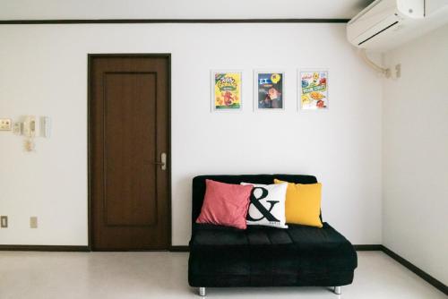 um quarto com um sofá preto com almofadas coloridas em Il Sole Kujo - Vacation STAY 8471 em Osaka