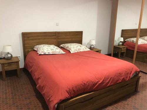 - une chambre avec un grand lit rouge et 2 oreillers dans l'établissement Gîte dans le pré Hesdin l'abbé, à Carly