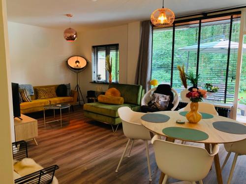 a living room with a table and chairs at Gouden Hert: relaxen in comfort! #otterlo #hogeveluwe in Otterlo