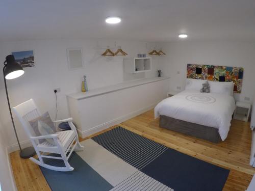 1 dormitorio con 1 cama y 1 silla en Grenane Heights Getaway en Kenmare