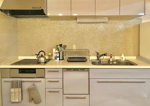 uma cozinha com armários brancos e um lavatório em Hakuba Shiro Usagi - Vacation STAY 87281 em Hakuba
