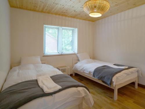 Duas camas num quarto com uma janela em Hakuba Shiro Usagi - Vacation STAY 87281 em Hakuba