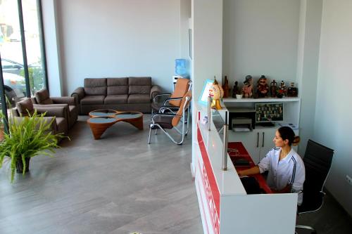 a woman sitting at a computer in a living room at Hotel Royal Georgia in Batumi