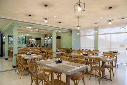 a restaurant with tables and chairs in a room at Vancouver Hotel- 500 Metros Rodovia Anhanguera in Ribeirão Preto