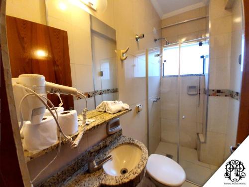 a bathroom with a sink and a shower with a sink at Portal Palace Hotel in Aparecida