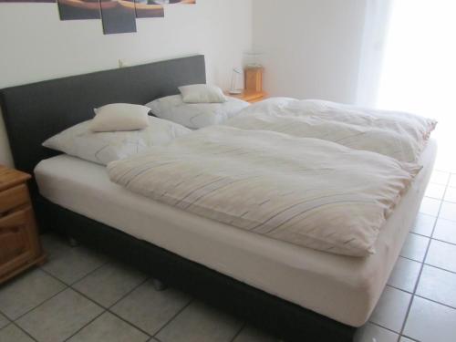 a bed with white sheets and pillows on it at Ferienwohnungen Fuchshuber in Neukirchen vorm Wald