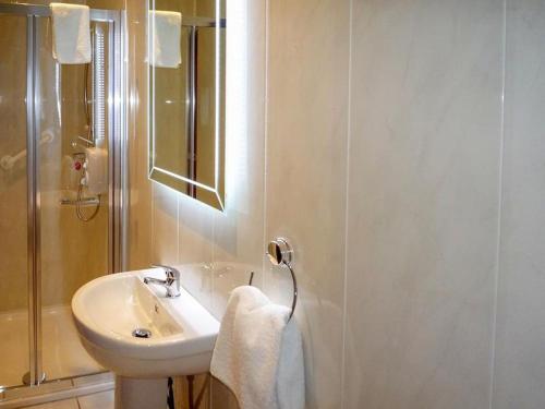 W białej łazience znajduje się umywalka i lustro. w obiekcie Beahy Lodge Holiday Home by Trident Holiday Homes w mieście Glenbeigh