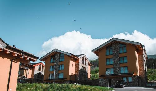 a row of apartment buildings in front of a mountain at Chalet Norvinga Jasná in Demanovska Dolina