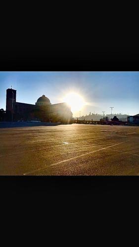 an empty parking lot with the sun in the background at Portal Palace Hotel in Aparecida