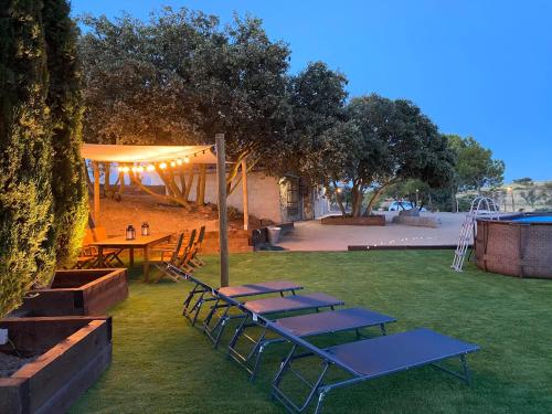 un gruppo di tavoli da picnic e una tenda in un parco di Mas de l'Aranyó - Eco Wellness Spa a Hostafranco