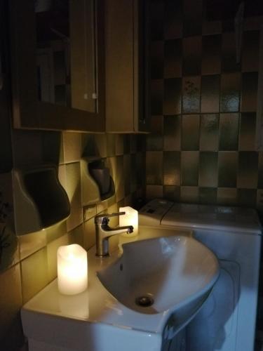 a bathroom with a sink and a candle on a counter at Rodomelo House with Terrace - 4 Bedrooms in Leonidion
