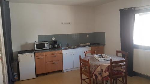 une petite cuisine avec une table et un micro-ondes dans l'établissement Appart simple entier 1 ch à ch-gontier 1er ou 2eme étage, à Château-Gontier