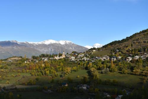 a small town on a hill with mountains in the background at Chalet Tres'Orres in Les Orres