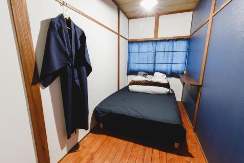 ein kleines Schlafzimmer mit einem Bett in einem Zimmer in der Unterkunft Couch Potato Hostel - Vacation STAY 88235 in Matsumoto