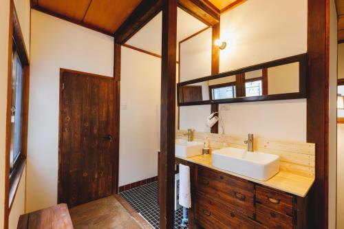 a bathroom with two sinks and a mirror at Couch Potato Hostel - Vacation STAY 88235 in Matsumoto