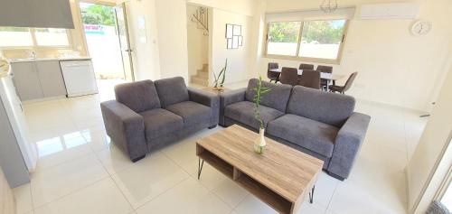 a living room with two couches and a table at Villa Naxos in Protaras