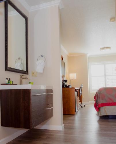 a bathroom with a sink and a bed in a room at Ramada by Wyndham Mountain View in Mountain View