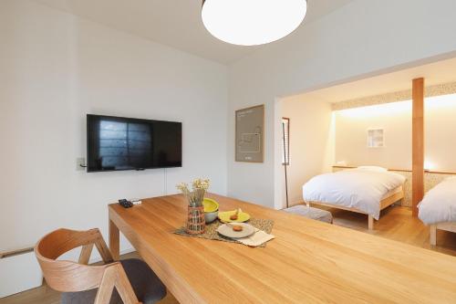 a living room with a table and a bed at hiyohiyo in Kanazawa