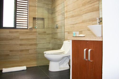 un baño con inodoro y lavabo en Sole Suites, en Playa del Carmen