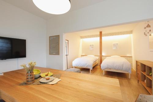 a living room with two beds and a table at hiyohiyo in Kanazawa