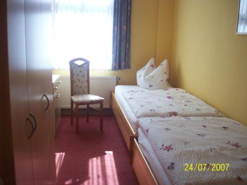 1 dormitorio pequeño con 1 cama y 1 silla en Ferienwohnung Rust en Oranienbaum-Wörlitz
