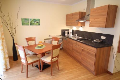 eine Küche und ein Esszimmer mit einem Tisch und Stühlen in der Unterkunft Hotel Cebulj in Bad Wörishofen
