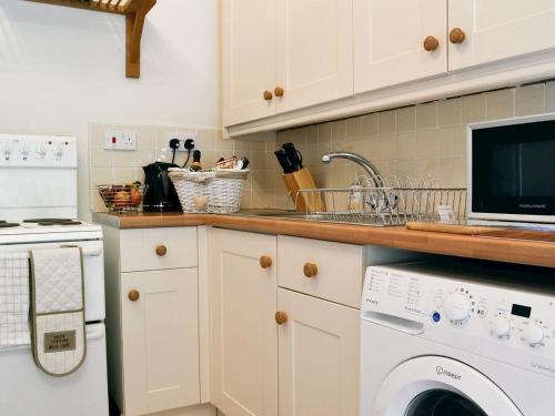 uma cozinha com um lavatório e uma máquina de lavar roupa em Ty-Gwyn em Abergavenny