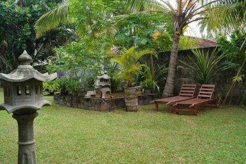 a garden with a bench and a table and chairs at Gästehaus Isabella in Beruwala