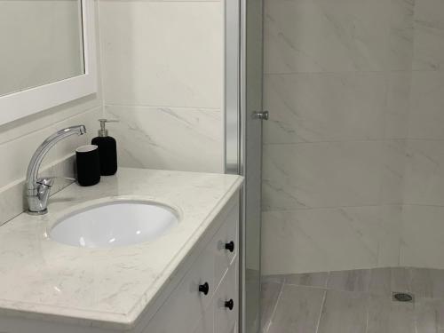 a white bathroom with a sink and a shower at Maya New Guest House -Panoramic Sea&CityCentre View, Haifa in Haifa