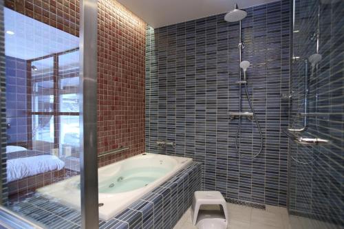 a bathroom with a bath tub and a shower at 2nd floor of 3rd NEO building - Vacation STAY 88300 in Sapporo