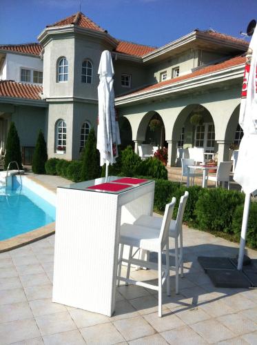 a table and chairs and an umbrella in front of a house at Sunny House in Skopje
