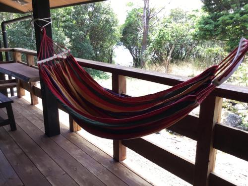 a hammock hanging from a wooden railing on a porch at Kumage-gun - House - Vacation STAY 84975 in Yudomari