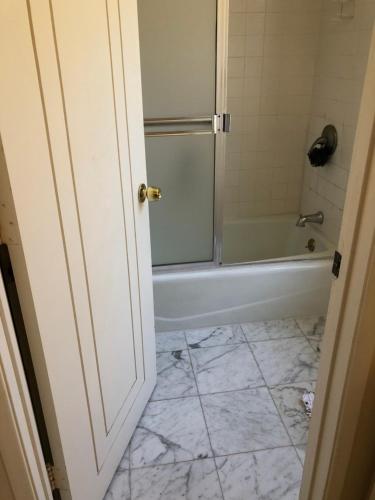 baño con ducha y bañera y suelo de baldosa. en Hollywood Hills private room, en Los Ángeles
