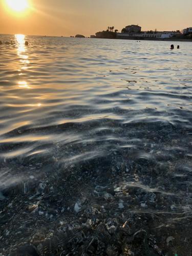 a body of water with the sun setting in the background at La Risacca Relais in Belvedere Marittimo