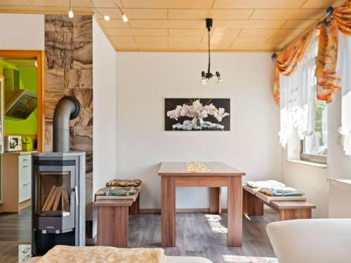 a living room with a table and a stove at Apartment with garden view in the Erzgebirge in Pöhla