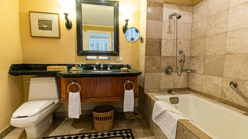 a bathroom with a tub and a toilet and a sink at Pierre Mundo Imperial Riviera Diamante Acapulco in Acapulco