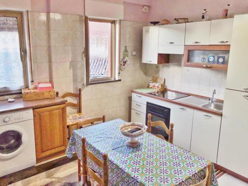 cocina con mesa, mesa y fregadero en Appartamento Maria Giovanna, en Giardini Naxos