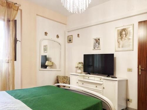 ジャルディーニ・ナクソスにあるAppartamento Maria Giovannaのベッドルーム(ベッド1台、ドレッサー内のテレビ付)