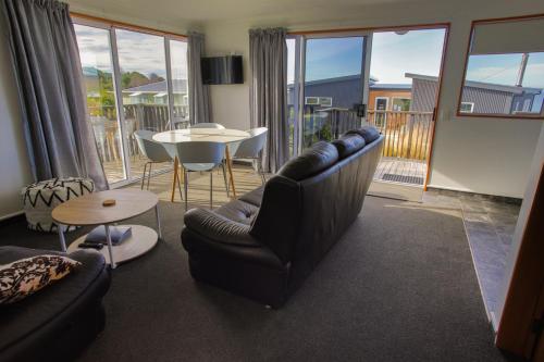 a living room with a couch and a table at Nugget View Kaka Point Motels in Kaka Point