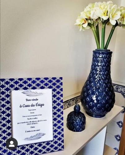 a blue vase with a certificate and a card on a shelf at Casa Da Veiga in Caminha