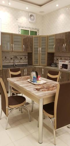 a kitchen with a large wooden table and chairs at Dar Al Karama Residential Units in AlUla
