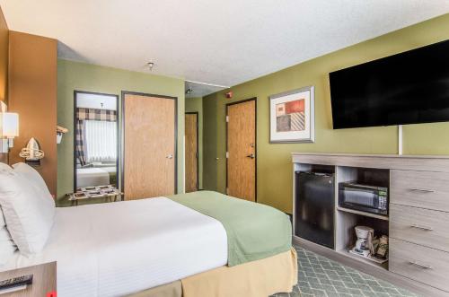 a bedroom with a large bed and a flat screen tv at GuestHouse Inn & Suites Poulsbo in Poulsbo